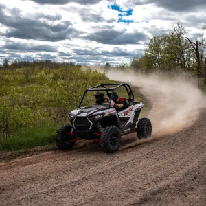 a motorcycle parked on the side of a dirt road