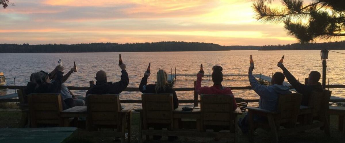 a group of people sitting on a bench next to a body of water