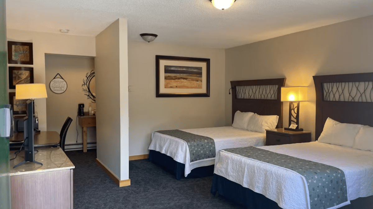 a bedroom with a bed and desk in a hotel room