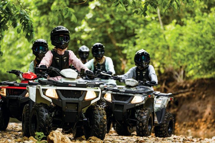 a man riding a motorcycle down a dirt road