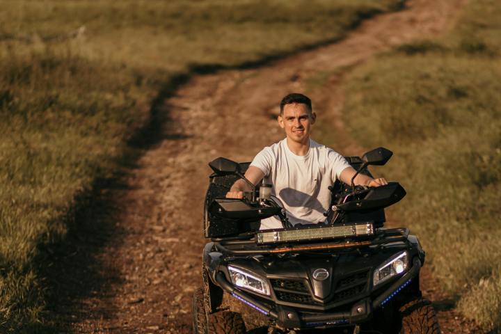a man riding a motorcycle down a dirt road